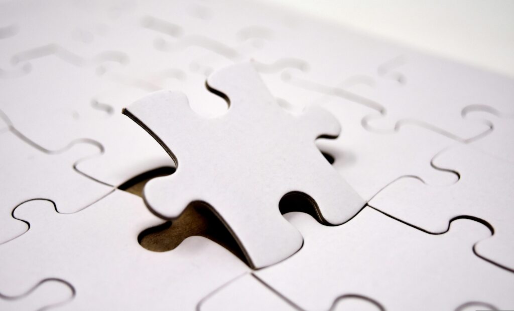A single white jigsaw puzzle piece fitting into place. Ideal for concepts of problem-solving and solutions.